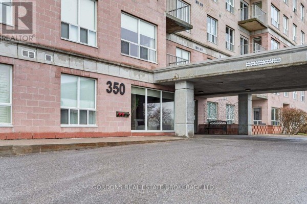 Covered entrance to apartment building 350 with cream brick facade and concrete columns. - 401 - 350 Wellington Street, Kingston