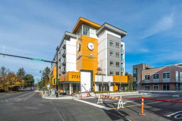 Apartment building exterior with a prominent clock tower and street view. - 401 27215 Aldergrove Town Centre Drive, Langley