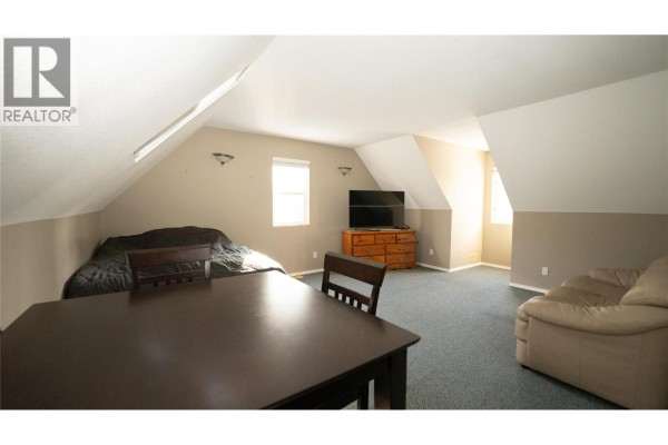 Kitchen featuring wooden cabinets, stainless steel appliances, and breakfast bar - 401 Gillis Avenue, Sicamous
