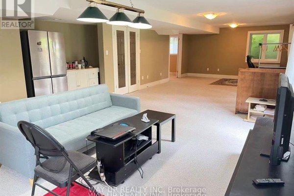 Spacious living area with light blue sofa, kitchen counter, and double doors. - 401 Kingbird Court, London North