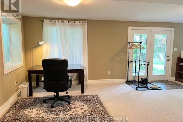 Home office area with a desk, chair, rug, and double glass doors. - 401 Kingbird Court, London North