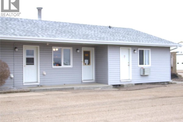 Exterior view of motel with gray siding and multiple entrances - 401 Martin Street, Burstall