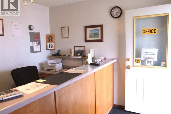 Reception area with wooden counter, clock, and office supplies - 401 Martin Street, Burstall