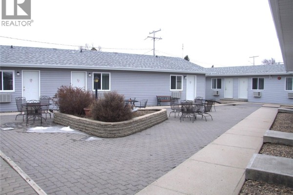 Courtyard with seating, planters, and gray siding on surrounding units - 401 Martin Street, Burstall
