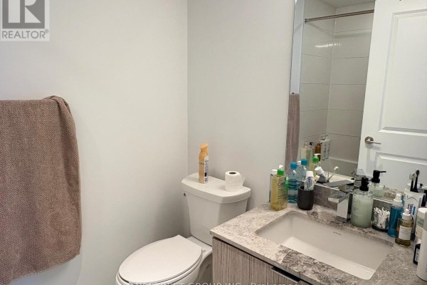 Bathroom with white toilet, granite countertop vanity, and shower stall with tiled walls. - 4010 - 395 Bloor Street E, Toronto