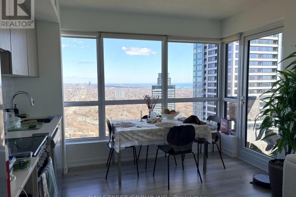 Dining area with a table and chairs, adjacent to a kitchen and large windows with city views. - 4010 - 395 Bloor Street E, Toronto