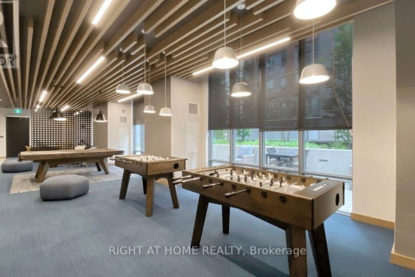 Game room with pool table, foosball tables, blue carpet, and a wood-slat ceiling. - 4013 - 108 Peter Street, Toronto
