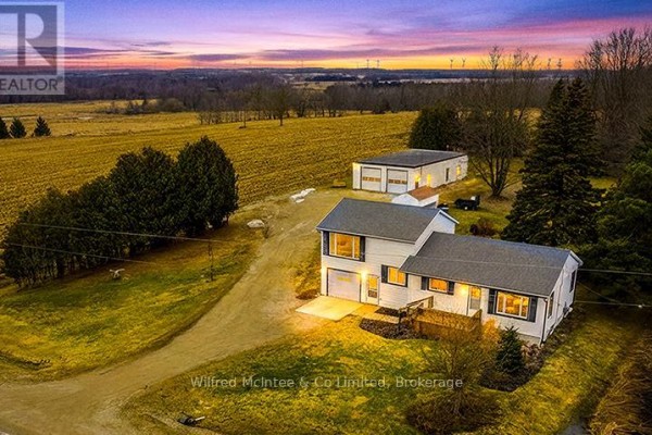 Rural home with detached garage and fields at dusk - 401395 Grey Rd 4 West Grey