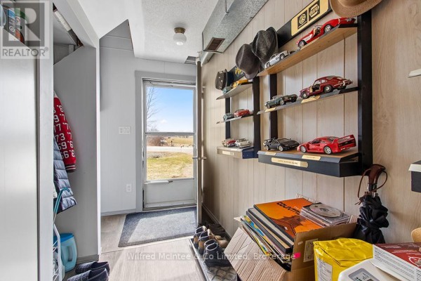 Model car collection on shelves, coats, hats, and door to exterior - 401395 Grey Rd 4 West Grey