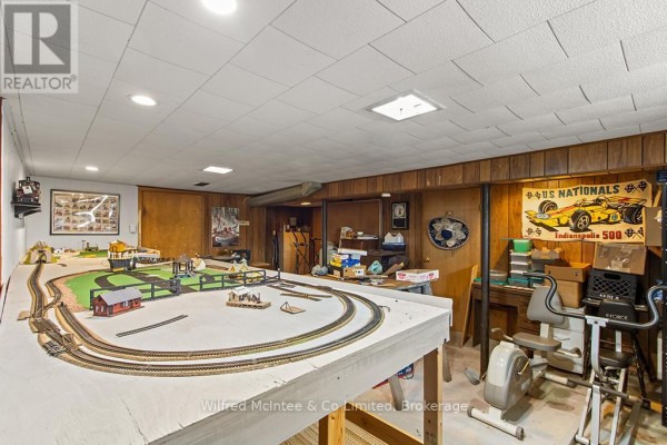Model train set and exercise bike in a room with wood paneling - 401395 Grey Rd 4 West Grey