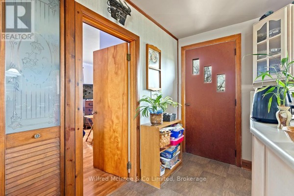 Hallway with wooden doors, frosted glass panel, and storage shelves - 401395 Grey Rd 4 West Grey