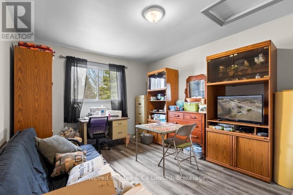 Futon, sewing machine, desk, and TV in room - 401395 Grey Rd 4 West Grey