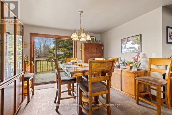 Wooden dining table and chairs with view to deck through sliding door - 401395 Grey Rd 4 West Grey