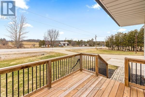Wooden deck with black railings and rural view - 401395 Grey Rd 4 West Grey
