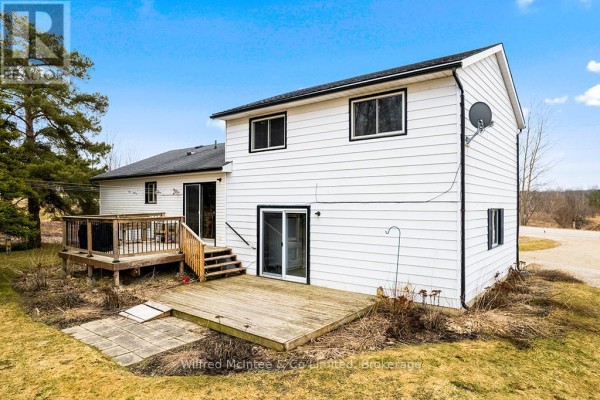 White vinyl-sided house with two wooden decks and a paved patio area - 401395 Grey Rd 4 West Grey
