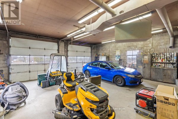 Garage with blue sedan, riding lawn mower, snow blower, generator & storage - 401395 Grey Rd 4 West Grey