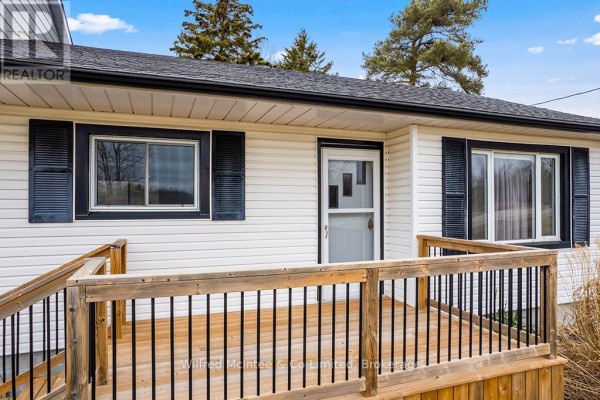 Wooden deck with black railings and front door on house exterior - 401395 Grey Rd 4 West Grey