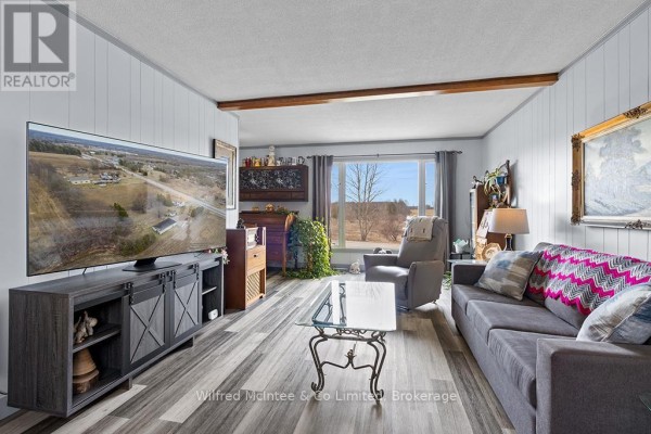 Living room with large TV, sofa, recliner, and scenic window view - 401395 Grey Rd 4 West Grey
