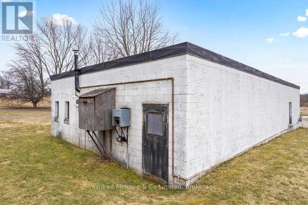 White cinder block building with shed and door - 401395 Grey Rd 4 West Grey