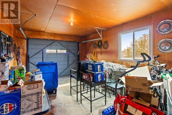 Garage with garage door, window, storage boxes, bar stools, and golf clubs - 401395 Grey Rd 4 West Grey