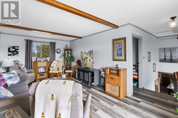Living room with fireplace, TV, sofas, and wood beams - 401395 Grey Rd 4 West Grey