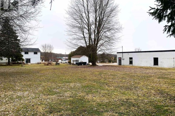 White house, garage, commercial building, and large tree on a lot - 401395 Grey Rd 4 West Grey