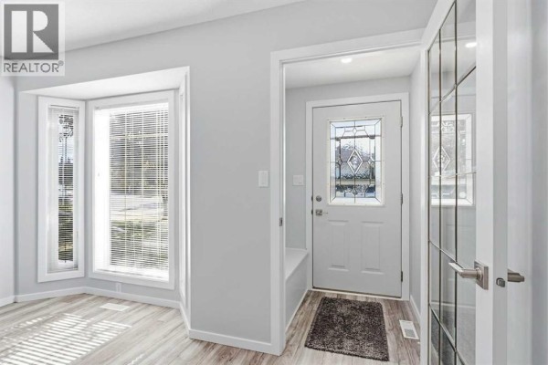 Close-up of the front door of the duplex, with a black address plaque numbered 4014. - 4014 Shannon Drive, Olds