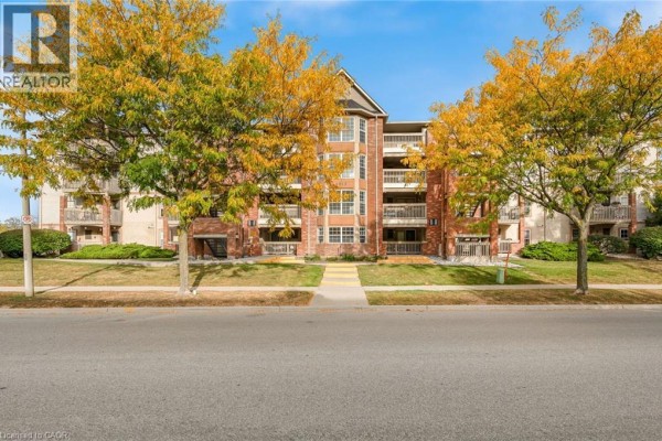 Exterior view of brick apartment building with balconies and trees with fall foliage. - 4015 Kilmer Drive Unit# 204, Burlington