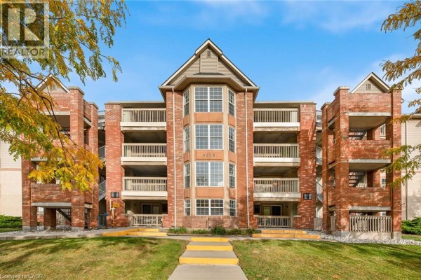 Front exterior of brick apartment building with central window features and balconies. - 4015 Kilmer Drive Unit# 204, Burlington