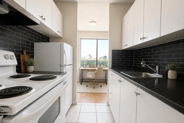 Galley kitchen with white cabinets, black subway tile backsplash, and a white stove. - 402 - 1780 Lawrence Avenue E, Toronto