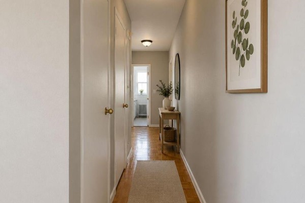 Interior hallway with light grey walls, hardwood floors, and a console table. - 402 - 1780 Lawrence Avenue E, Toronto