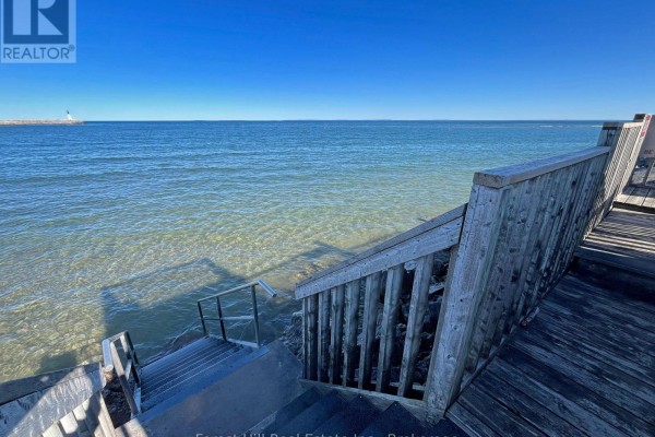 Wooden stairs and deck leading down to clear water with a lighthouse in the distance. - 402 - 24 Ramblings Way, Collingwood