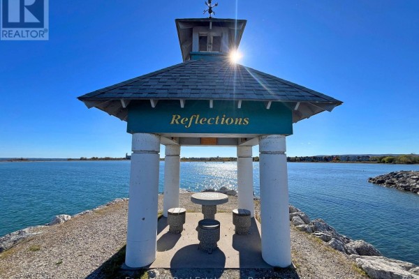 Gazebo with a table and seating on a rocky shoreline by the water. - 402 - 24 Ramblings Way, Collingwood
