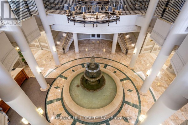 View from above of the building lobby featuring a fountain, marble floor, columns, and chandelier. - 402 - 35 Kingsbridge Garden Circle, Mississauga