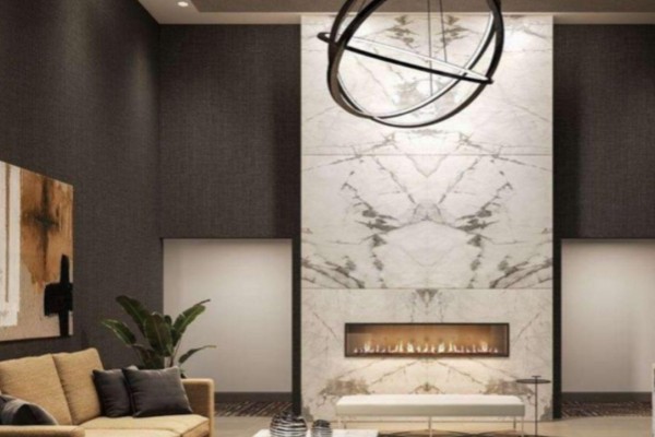 Lobby interior with a large marble fireplace, modern art, and a beige sofa. - 402 - 460 Gordon Krantz Avenue, Milton