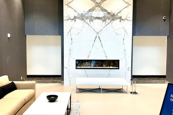 Interior lobby with a long gas fireplace set into a marble feature wall. - 402 - 460 Gordon Krantz Avenue, Milton