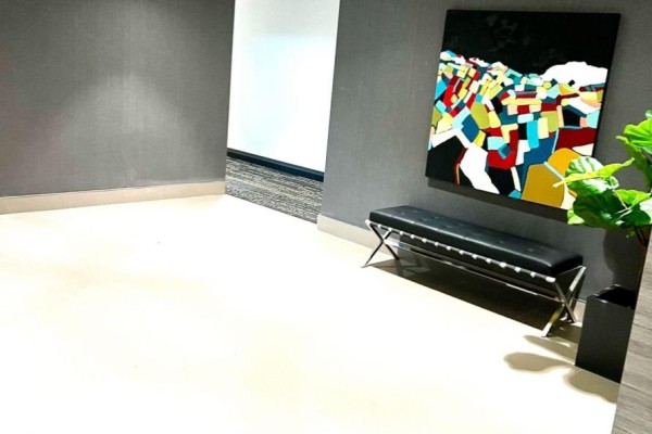 Interior hallway with gray textured walls, a colorful abstract painting, and a black bench. - 402 - 460 Gordon Krantz Avenue, Milton