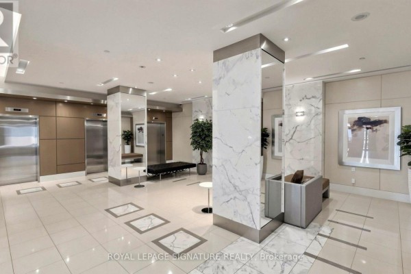 Apartment building lobby with elevator doors, marble accents, and contemporary seating. - 402 - 500 St Clair Avenue W, Toronto
