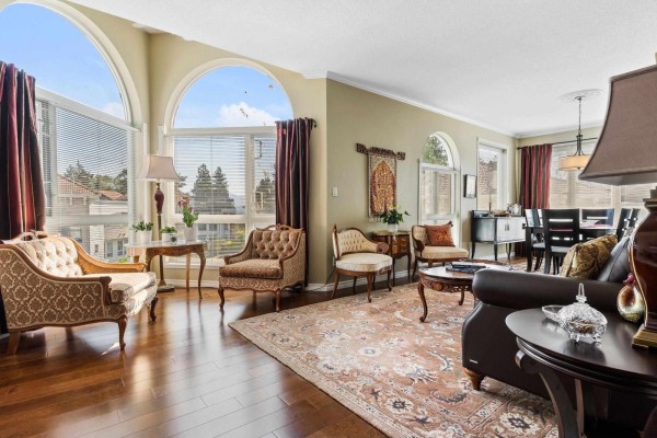 Bedroom with a queen-size bed, white bedding, marigold walls, and dark red curtains. - 402 3172 Gladwin Road, Abbotsford