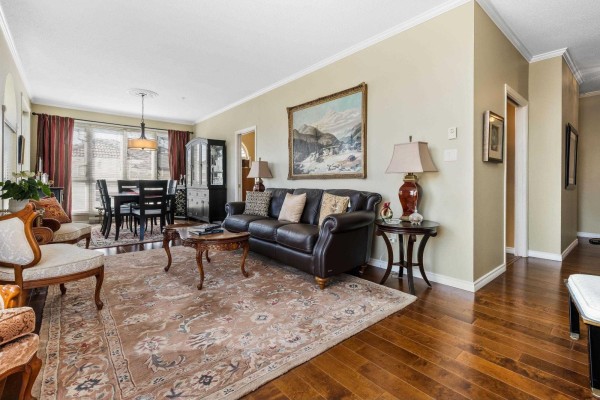 Kitchen with white appliances, wooden cabinets, and dark hardwood floors. - 402 3172 Gladwin Road, Abbotsford