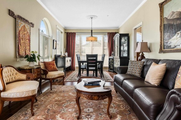 Living room with a fireplace, three recliners, and a large arched window overlooking the exterior. - 402 3172 Gladwin Road, Abbotsford