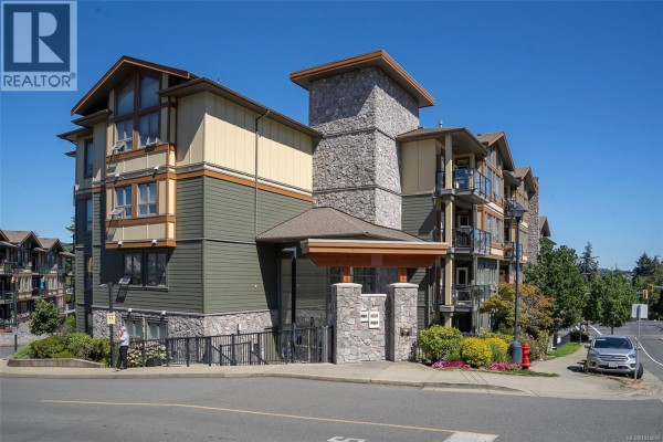 Side view of an apartment building showing balconies with glass railings. - 402 3210 Jacklin Rd, Langford
