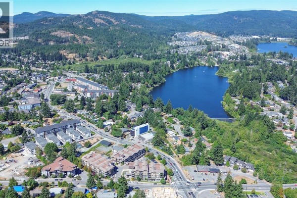 Aerial view of apartment buildings and surrounding roads with parked cars. - 402 3210 Jacklin Rd, Langford