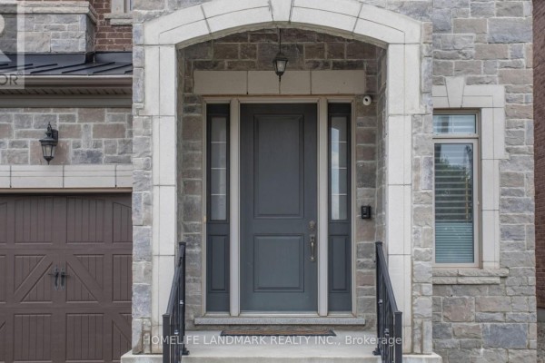 Close-up of the front entrance door with stone surround and side windows. - 402 Farrell Road, Vaughan