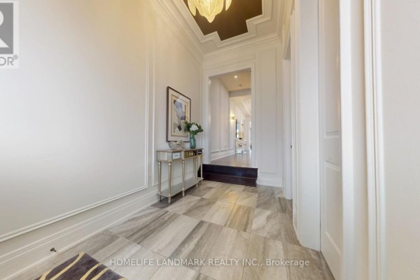 Hallway view showing marble tile floors, white walls, a console table, and doorways. - 402 Farrell Road, Vaughan