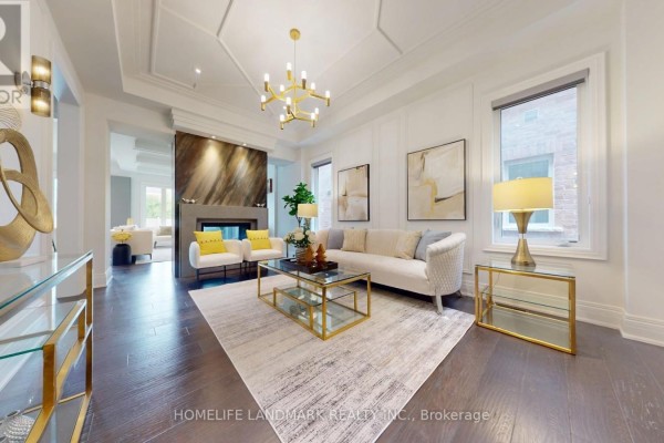 Living room with dark wood floors, a fireplace, a sofa, two armchairs, and a coffee table. - 402 Farrell Road, Vaughan