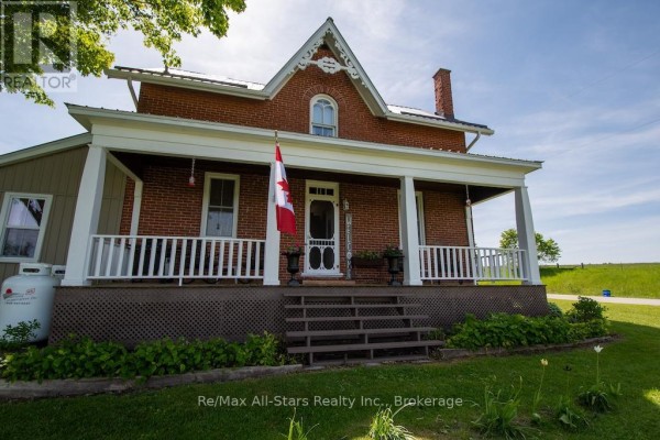 Living room with a leather recliner, large windows, and shelves displaying various items. - 402 Mount Horeb Road, Kawartha Lakes