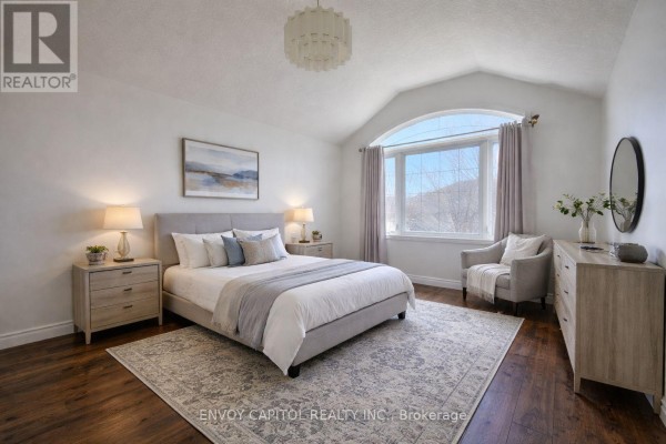 Bedroom with hardwood floors, vaulted ceiling, and arched window - 402 Palamino Place, Waterloo