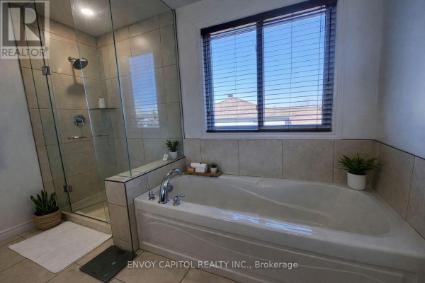 Modern bathroom with soaking tub, glass shower, and window - 402 Palamino Place Waterloo