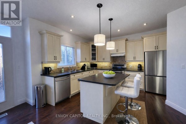 Kitchen with island, stainless steel appliances, hardwood floors - 402 Palamino Place, Waterloo